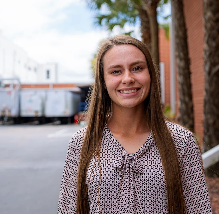 Young woman employee smiling outside Swisher’s warehouse