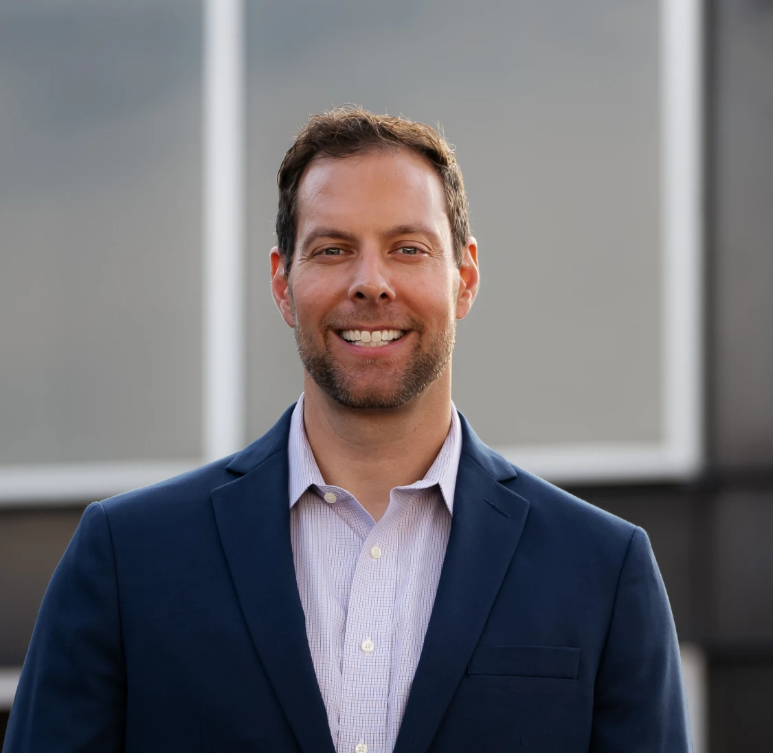 Smilling employee outside, in a suit.