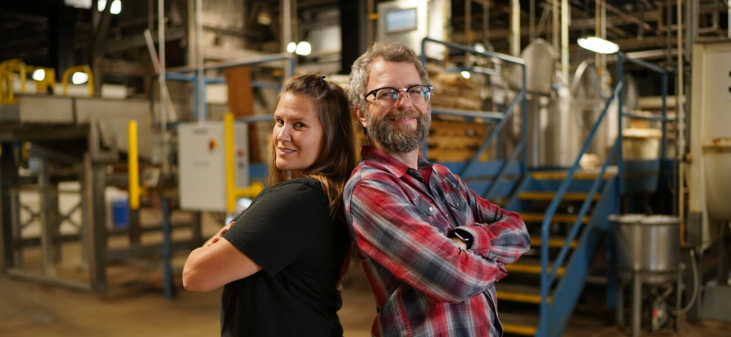 Man and woman employees, back to back, in Swisher warehouse