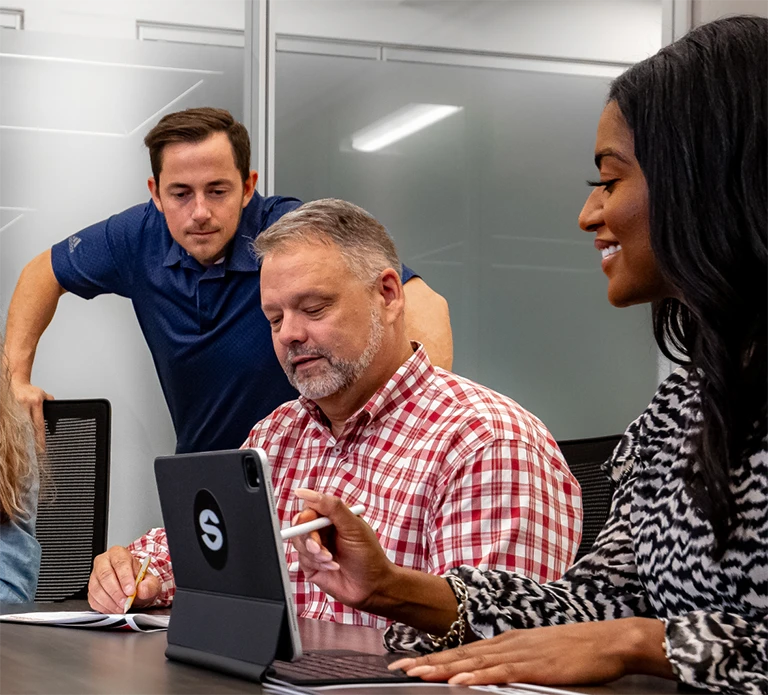 Diverse group of employee sharing data on laptop computer.