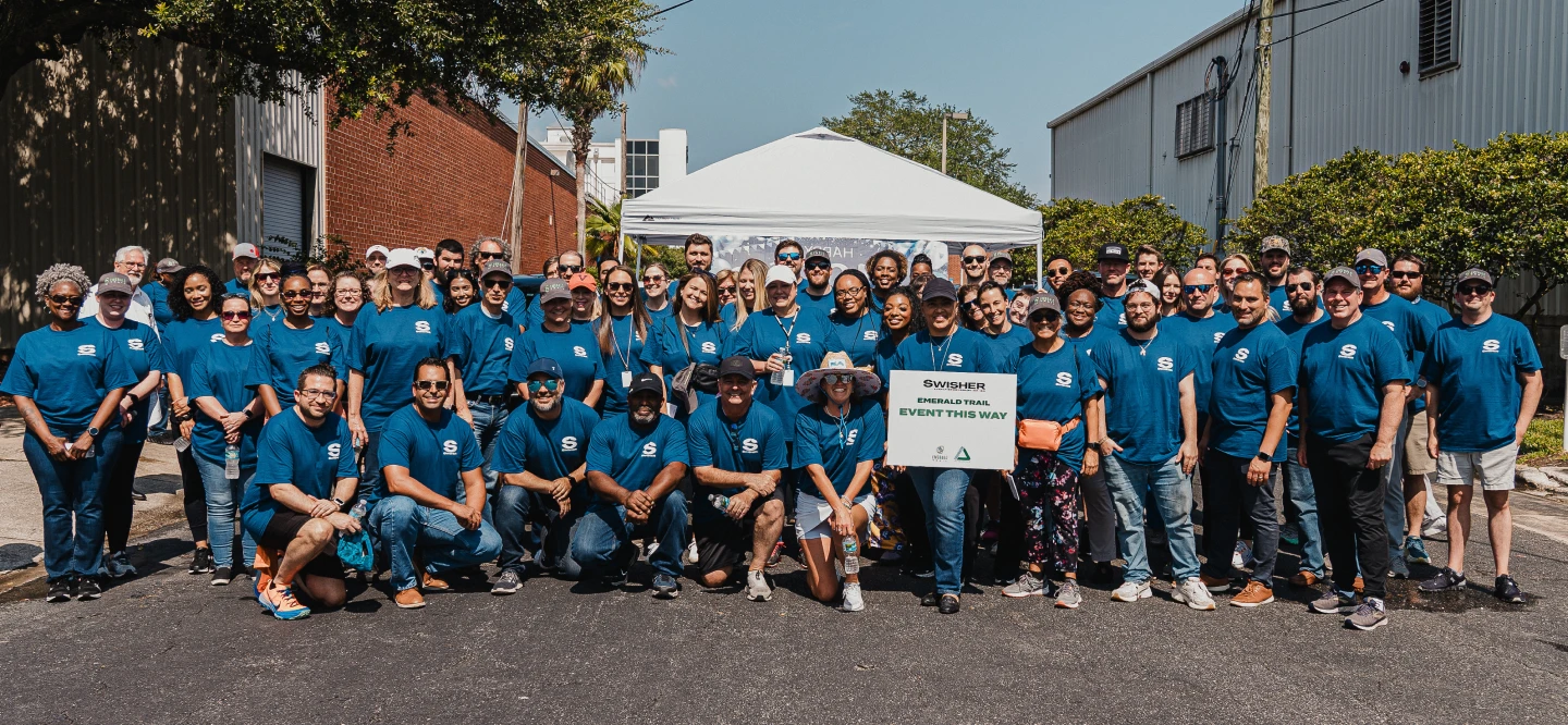 All Swishers employees all wearing blue shirts with the company logo for a group photo.