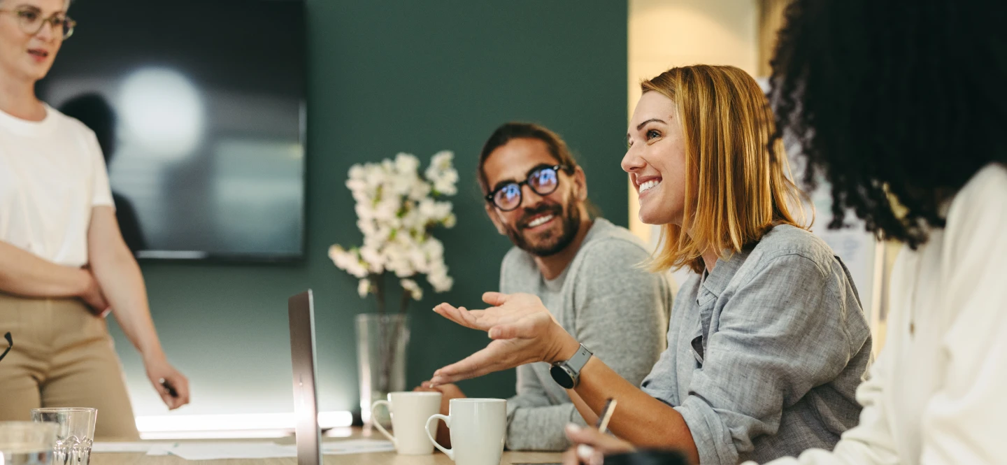 Diverse group of employees smilling during a meeting.